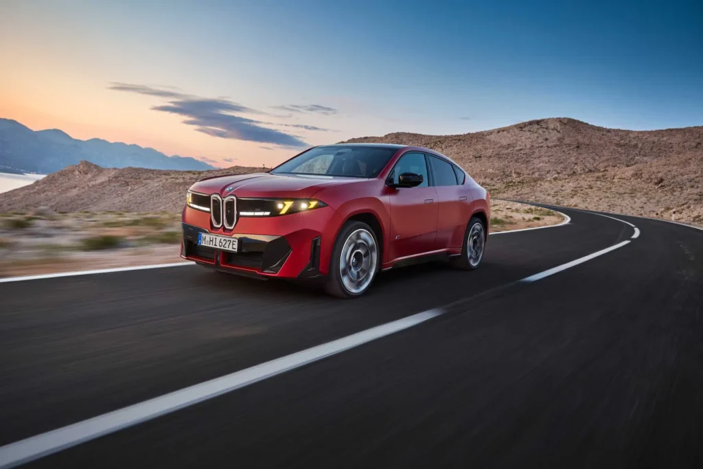 紅色BMW iX4 M60 xDrive純電跑旅行駛於山區公路