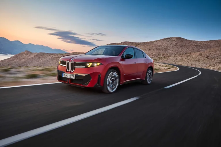 紅色BMW iX4 M60 xDrive純電跑旅行駛於山區公路