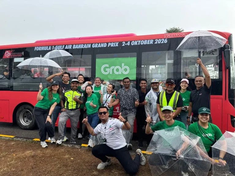 2026年雪邦F1期間Grab工作人員在紅色接駁巴士前合照