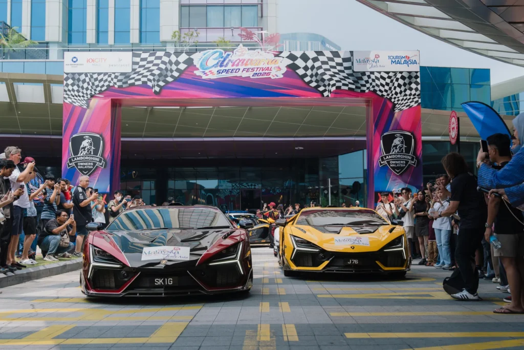 兩輛不同顏色的Lamborghini經過Citrawarna Speed Festival出發拱門,現場有觀眾及馬來西亞旅遊宣傳標誌