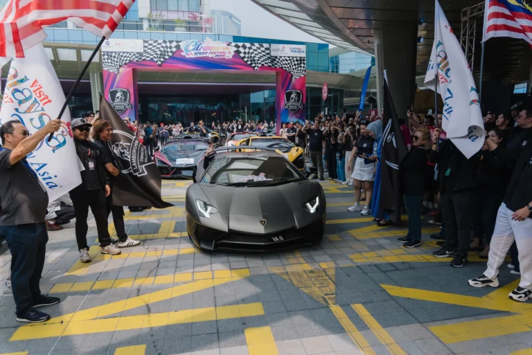 一輛灰色Lamborghini從布城IOI City Mall的活動拱門前駛出，旁邊是現場觀眾
